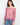 Elegant red blouse with a floral design, featuring an off-the-shoulder neckline and balloon sleeves. Styled with jeans by Charlie B.